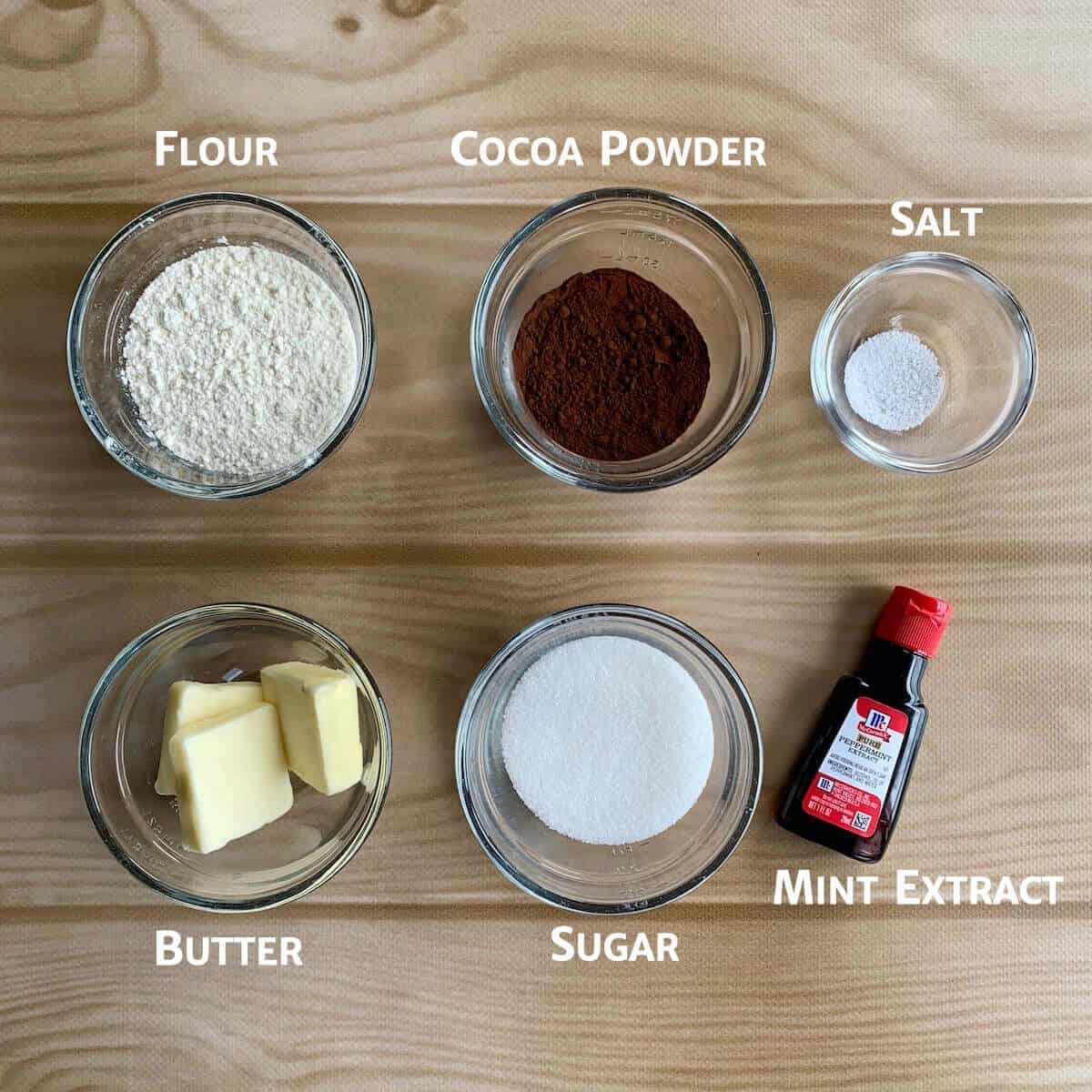 Chocolate cookie crumb ingredients portioned into glass bowls from overhead.