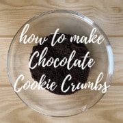 Chocolate cookie crumbs in a glass bowl from overhead Pinterest banner.