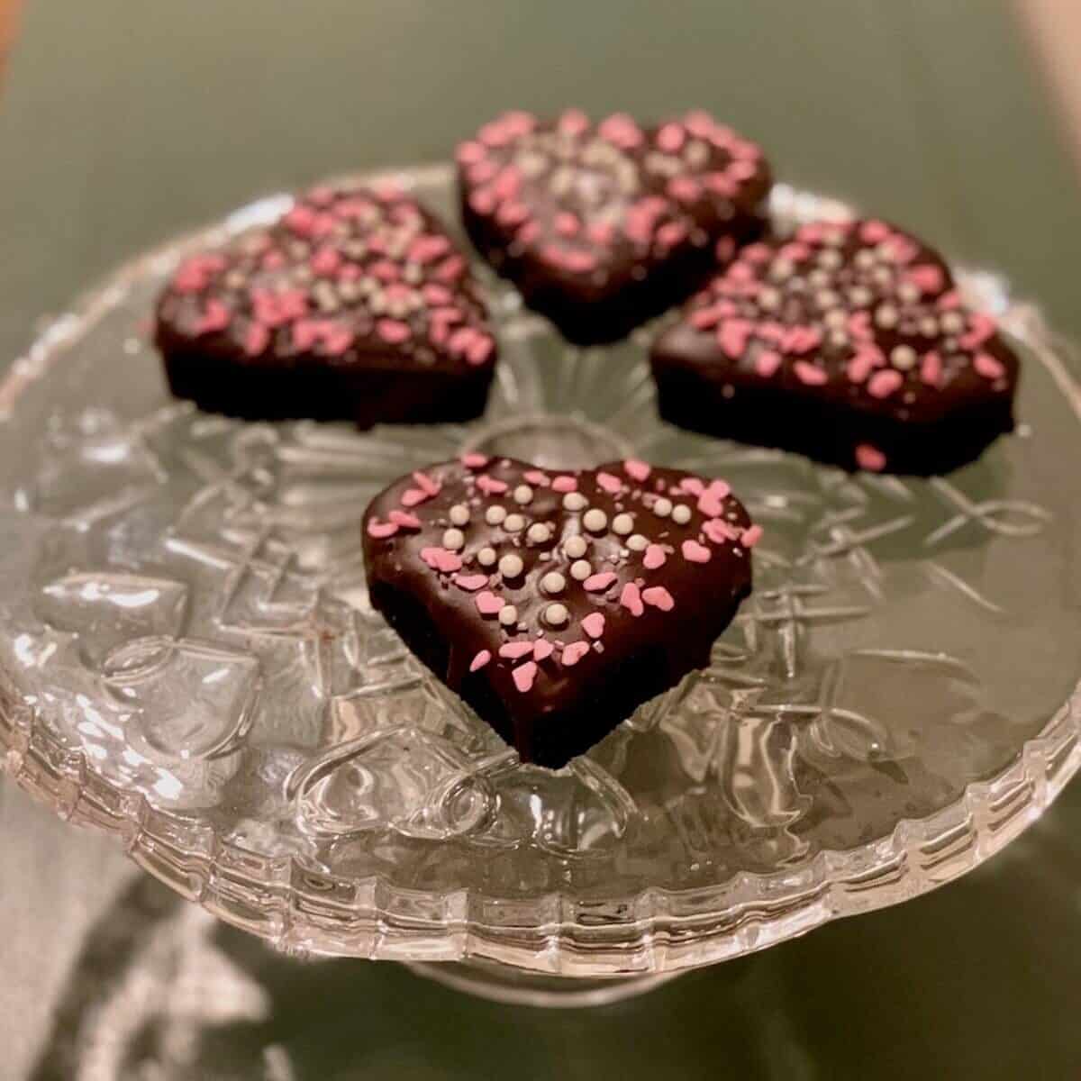 Port wine chocolate cake hearts on a glass cake stand.