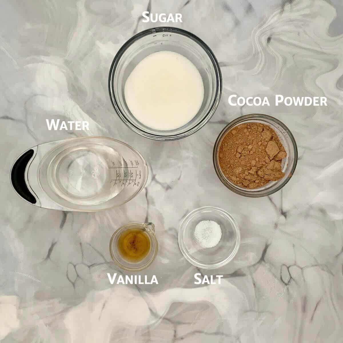 Chocolate syrup ingredients portioned into glass bowls from overhead.