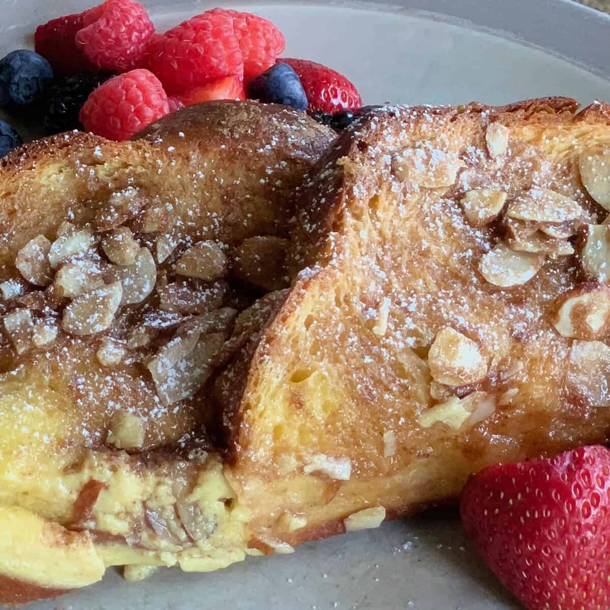 French Toast with berries on a grey plate.