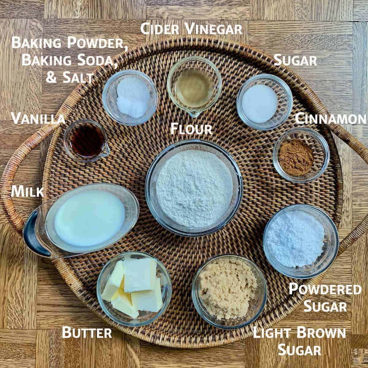 Quick Cinnamon Rolls ingredients portioned into glass bowls on a wooden tray.