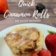 Cinnamon Rolls on a white plate with berries Pinterest banner..