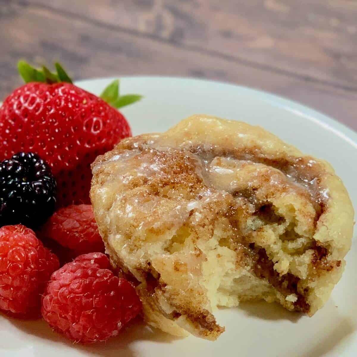 Cinnamon Rolls on a white plate with berries.