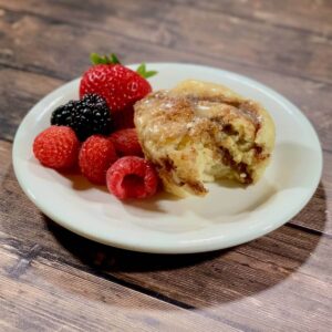 Cinnamon Rolls on a white plate with berries.