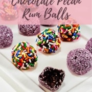 Rum balls with different topping with one bitten on a white plate Pinterest banner.