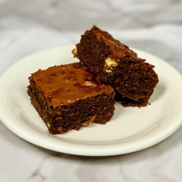 Two Triple Chocolate Brownies stacked on a white plate.