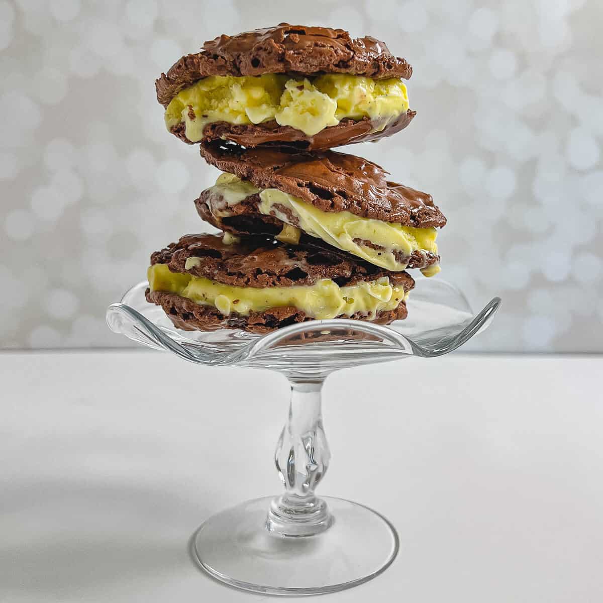 Gluten-Free Ice Cream Sandwiches stacked on glass cake stand.