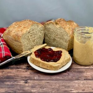 Multigrain Sourdough Sandwich Bread with PB&J slice on a white plate.