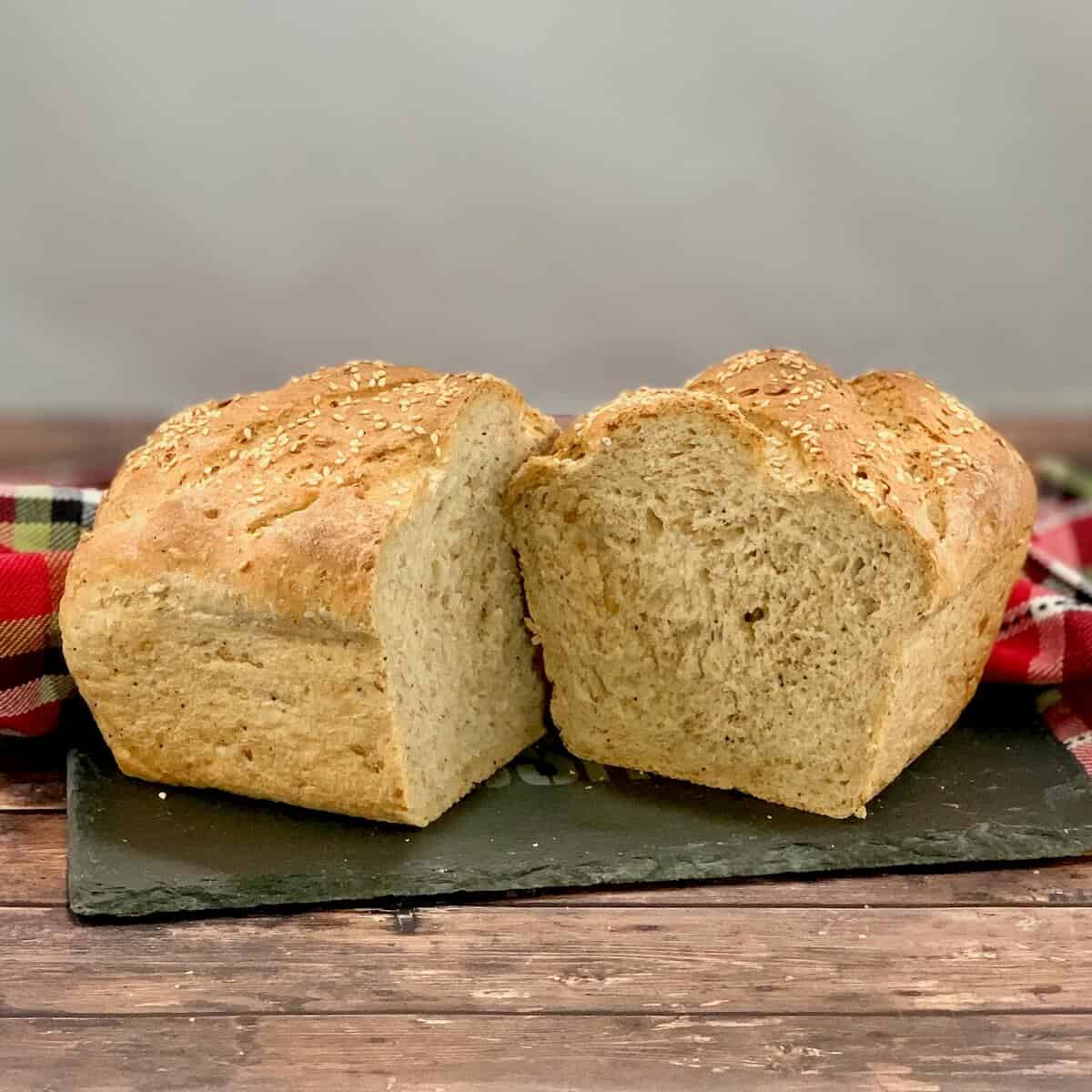 Halved Multigrain Sourdough Sandwich Bread loaf on slate.