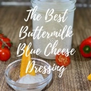 Buttermilk blue cheese dressing in a jar surrounded by tomatoes & cut bell peppers Pinterest banner.