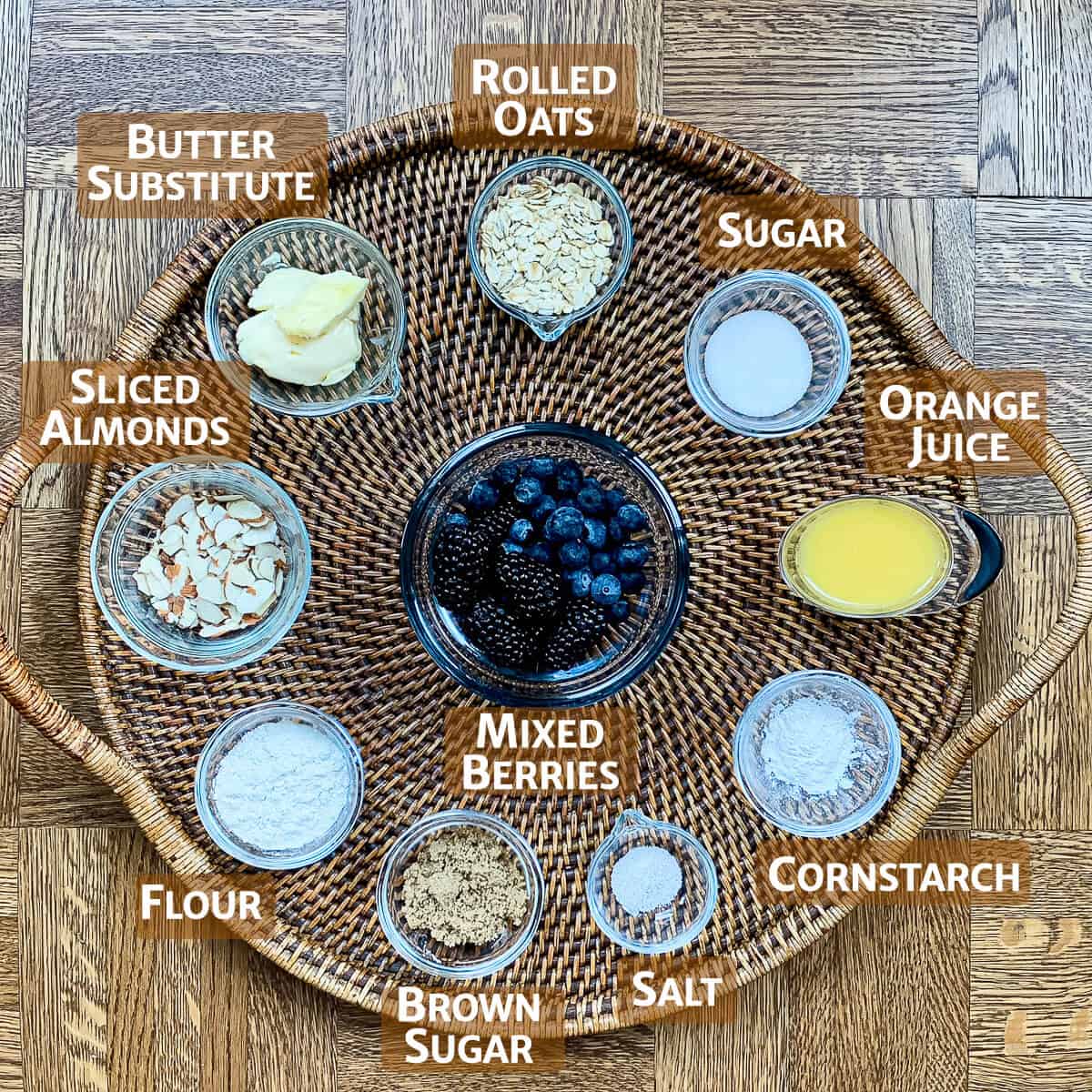 Skillet Berry Crisp portioned into glass bowls on a wooden tray.