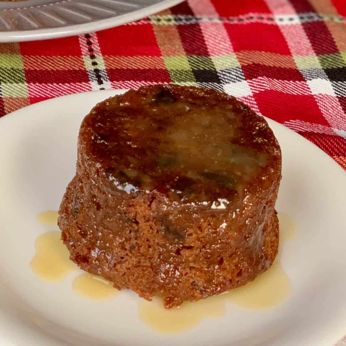Sticky Toffee Pudding on white plate on plaid napkin.