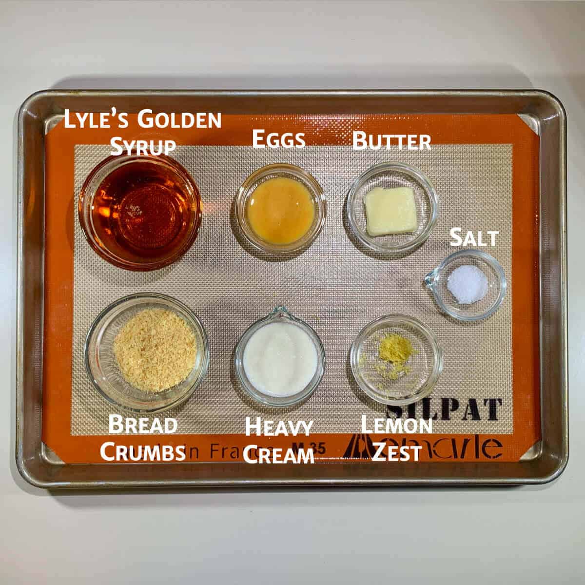 Treacle Tart ingredients portioned in glass bowls on a tray from overhead.