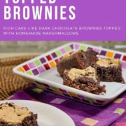 Marshmallow topped brownies on a white plate with more on a multicolored checked plate behind on a purple checked towel Pinterest banner.