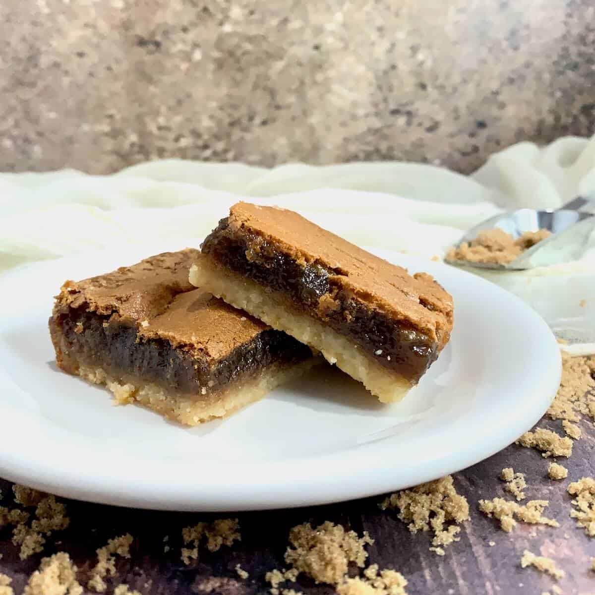 Two Brown Sugar Pie bars stacked on a white plate.