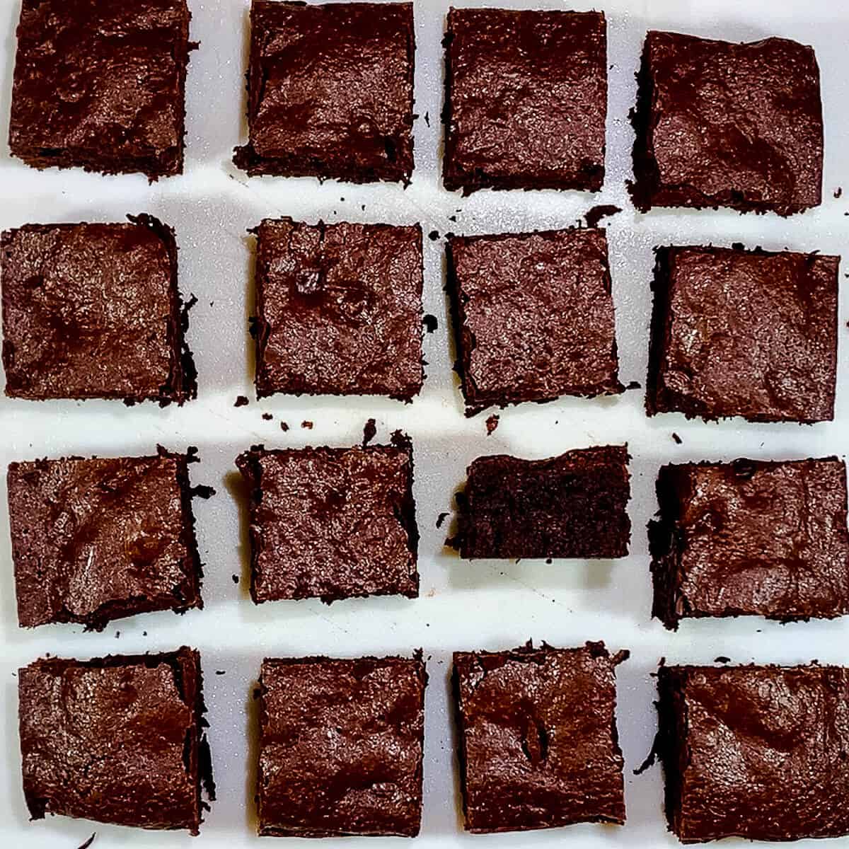 Cake brownies on cutting board cut with one sideways from overhead.