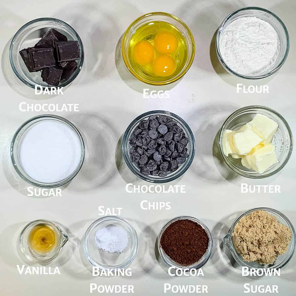 Cake brownies ingredients portioned into glass bowls from overhead.