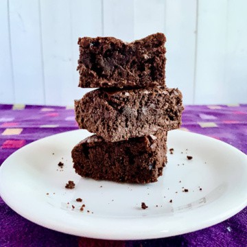 Stack of 3 cake brownies on white plate.