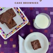Cake brownie on white plate with a stack of brownies & milk from overhead Pinterest banner.