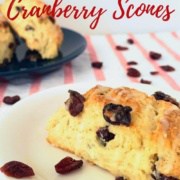 Orange Cranberry scone on white plate in foreground & stacked on blue plate in background Pinterest banner.