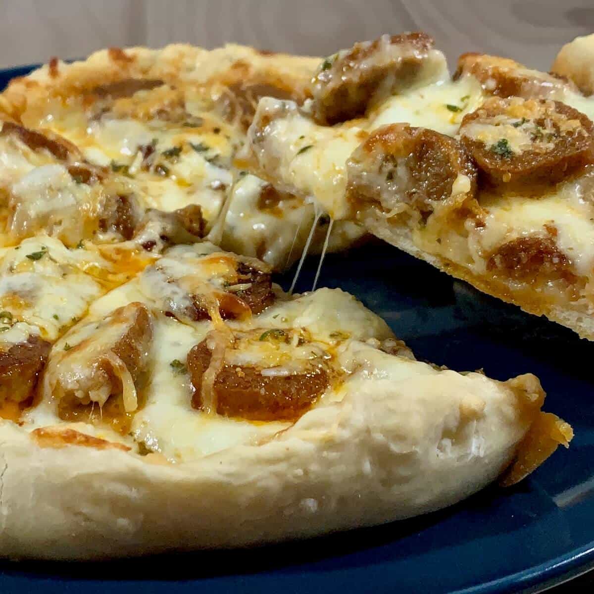 Sourdough Pizza on blue plate with a slice lifted.