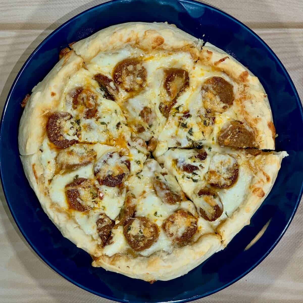 Sliced sourdough pizza on blue plate from overhead.