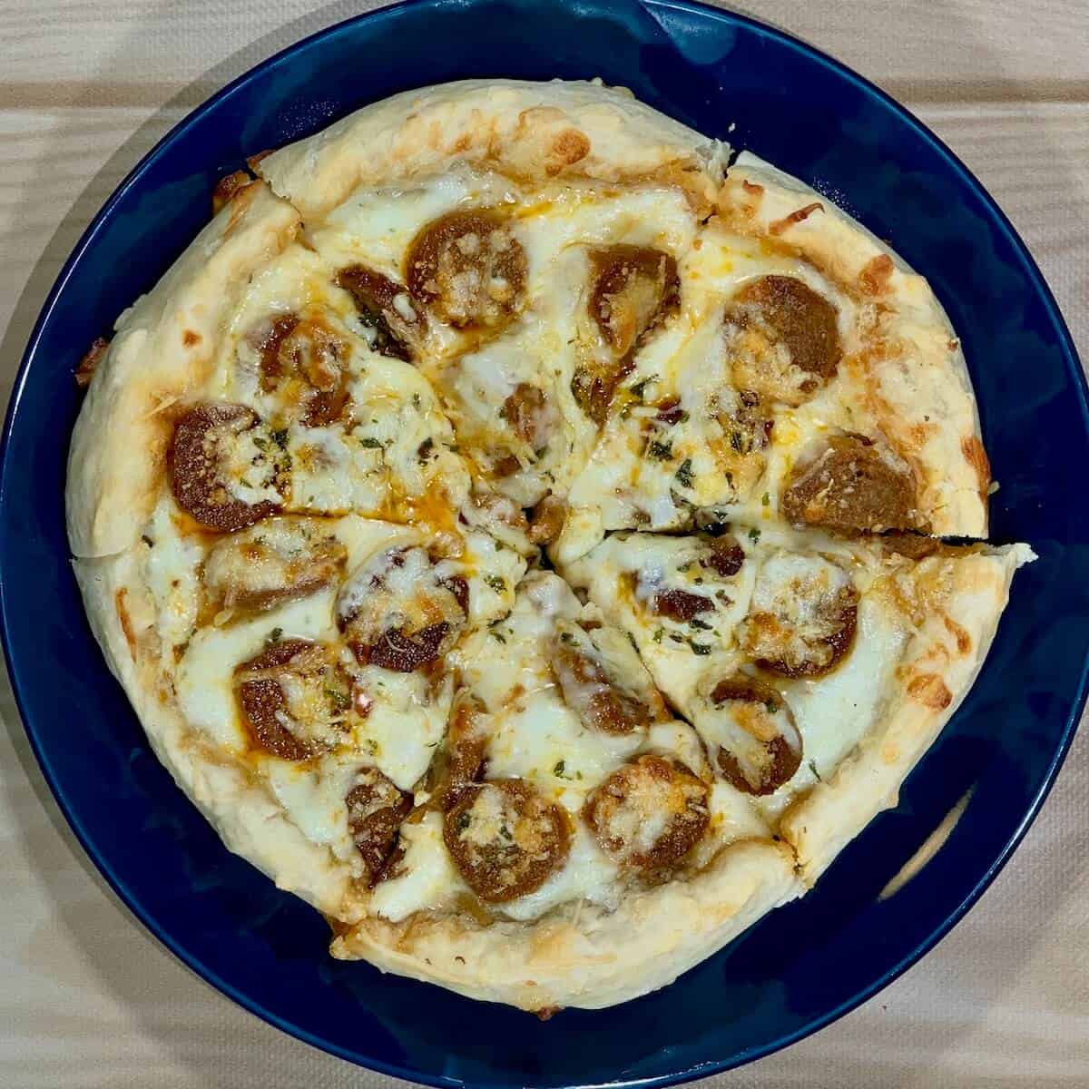 Sliced sourdough pizza on blue plate from overhead.