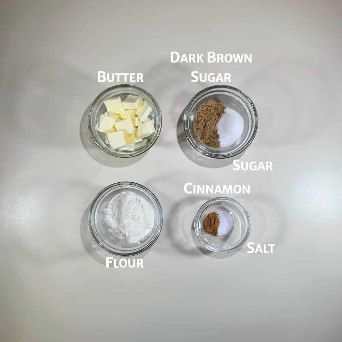 Streusel ingredients portioned into glass bowls from overhead.