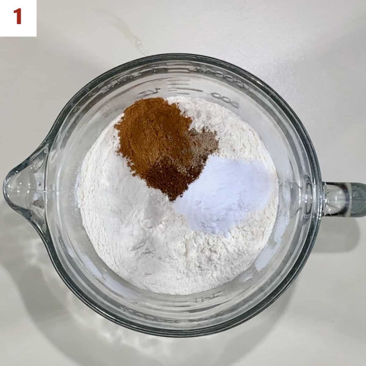 Flour, baking soda, salt, and spices in a glass bowl.