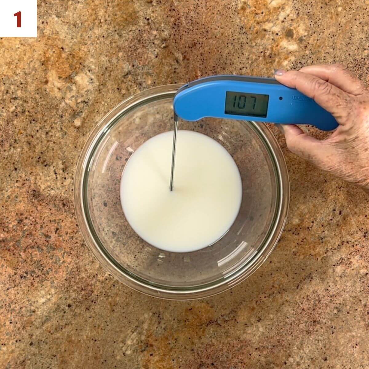 Testing the temperature of milk in a glass bowl.