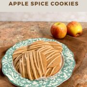 Apple spice cookies stacked on a plate with a green flowed edge and two apples behind Pinterest banner.