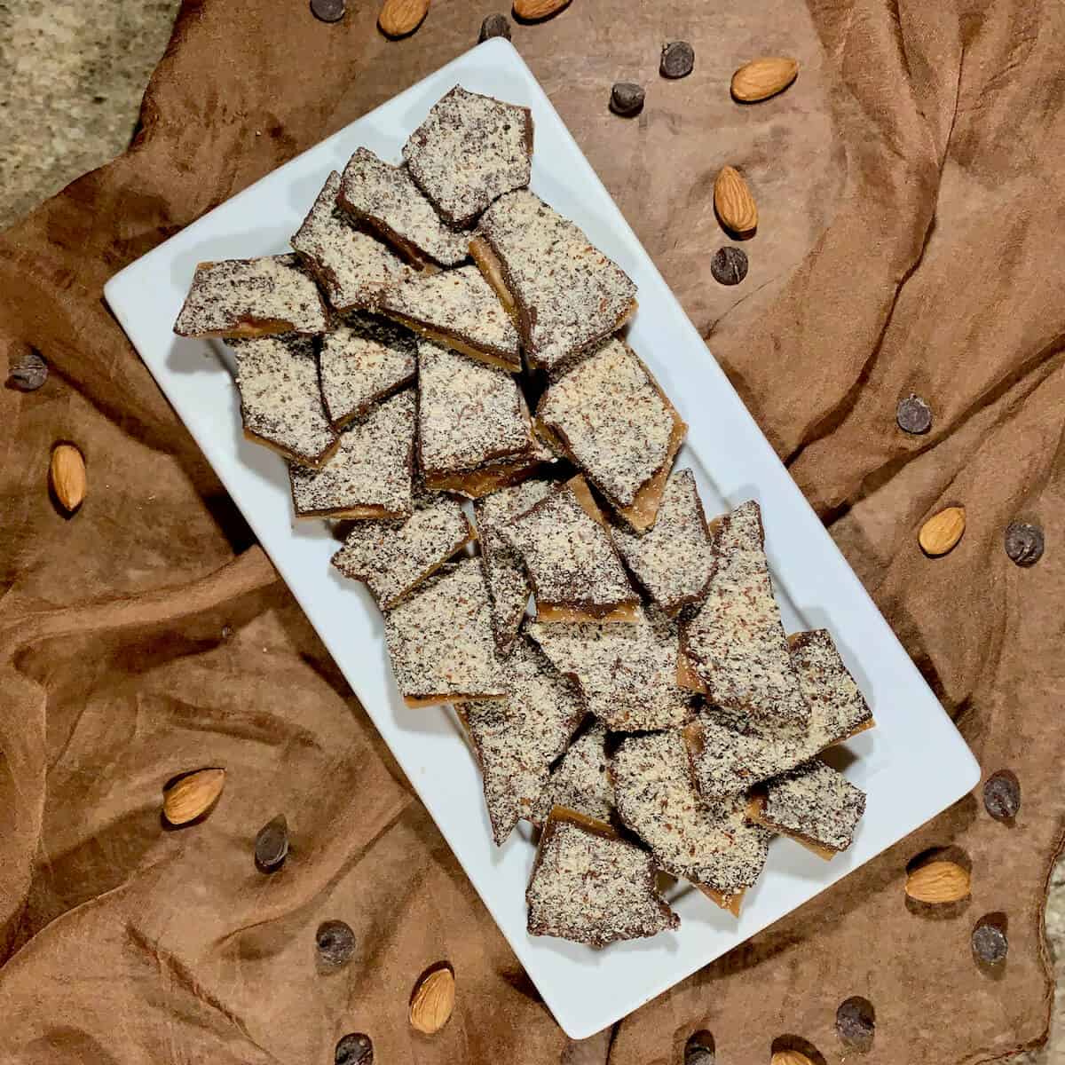 English Toffee laid out on a white plate over a brown scarf from overhead.