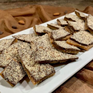 English Toffee laid out on a white plate over a brown scarf.