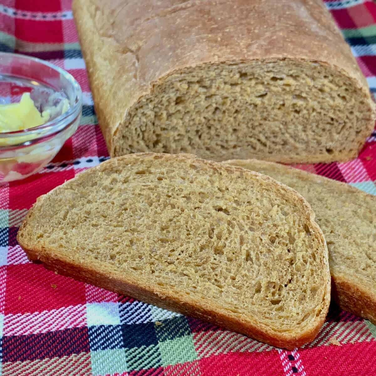 Colonial Bread slices on plaid towel with butter.