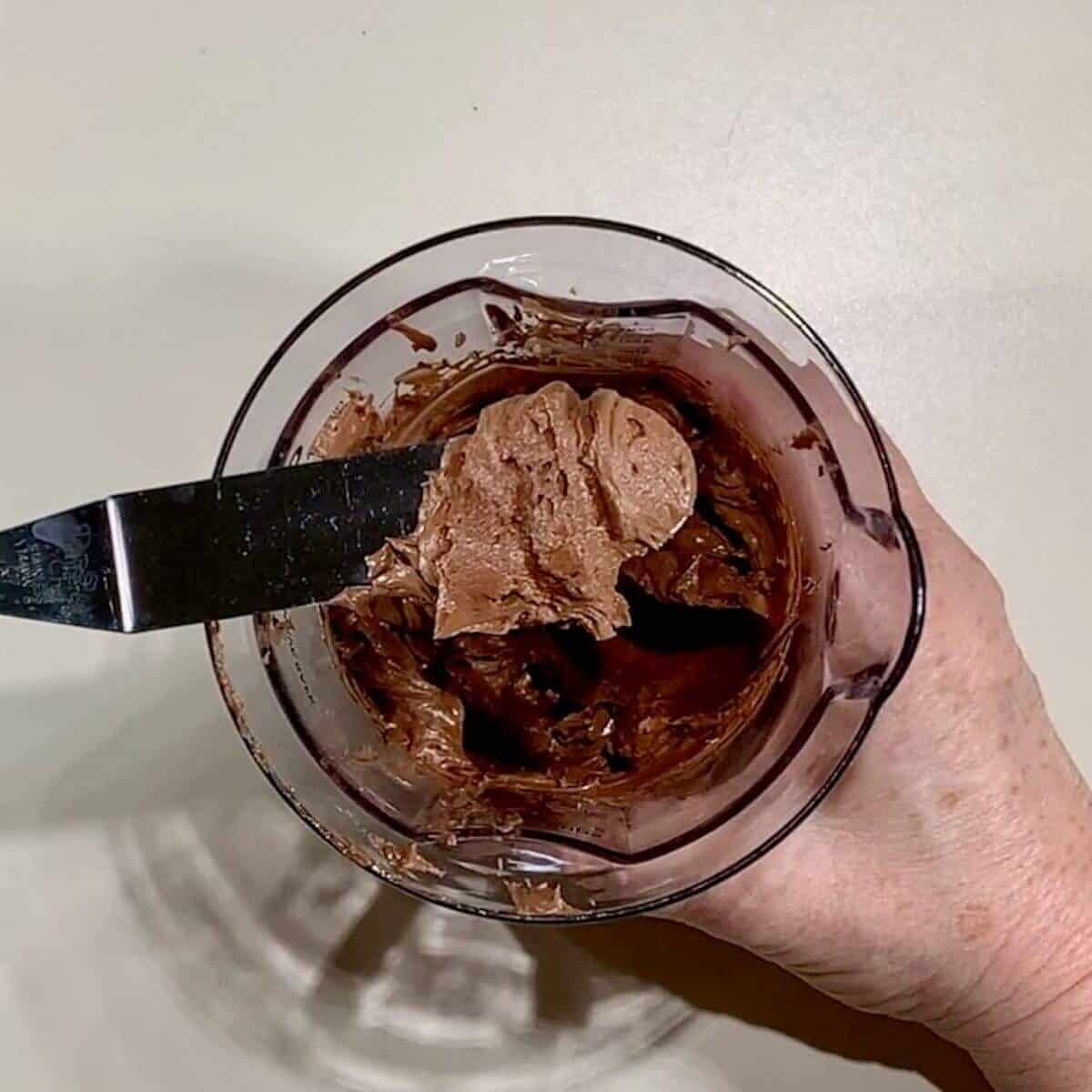 Whipped ganache frosting on a metal spatula from overhead.