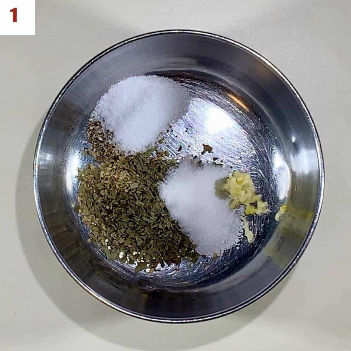 Mixing dry vinaigrette ingredients in a metal bowl.