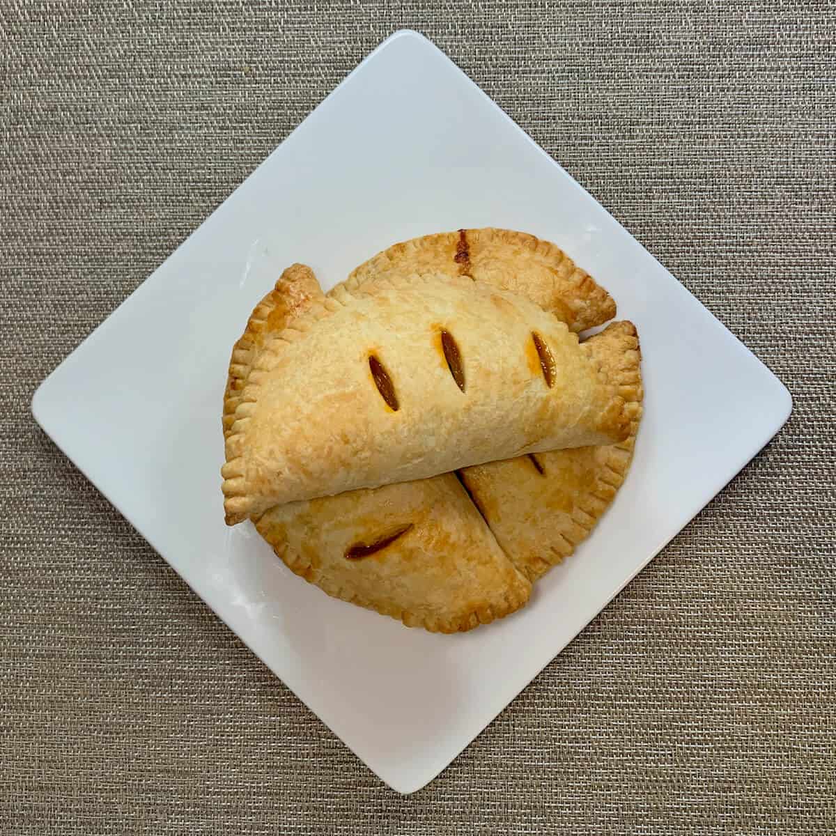 Four stacked Sloppy Joes Pasties on a white plate from overhead.