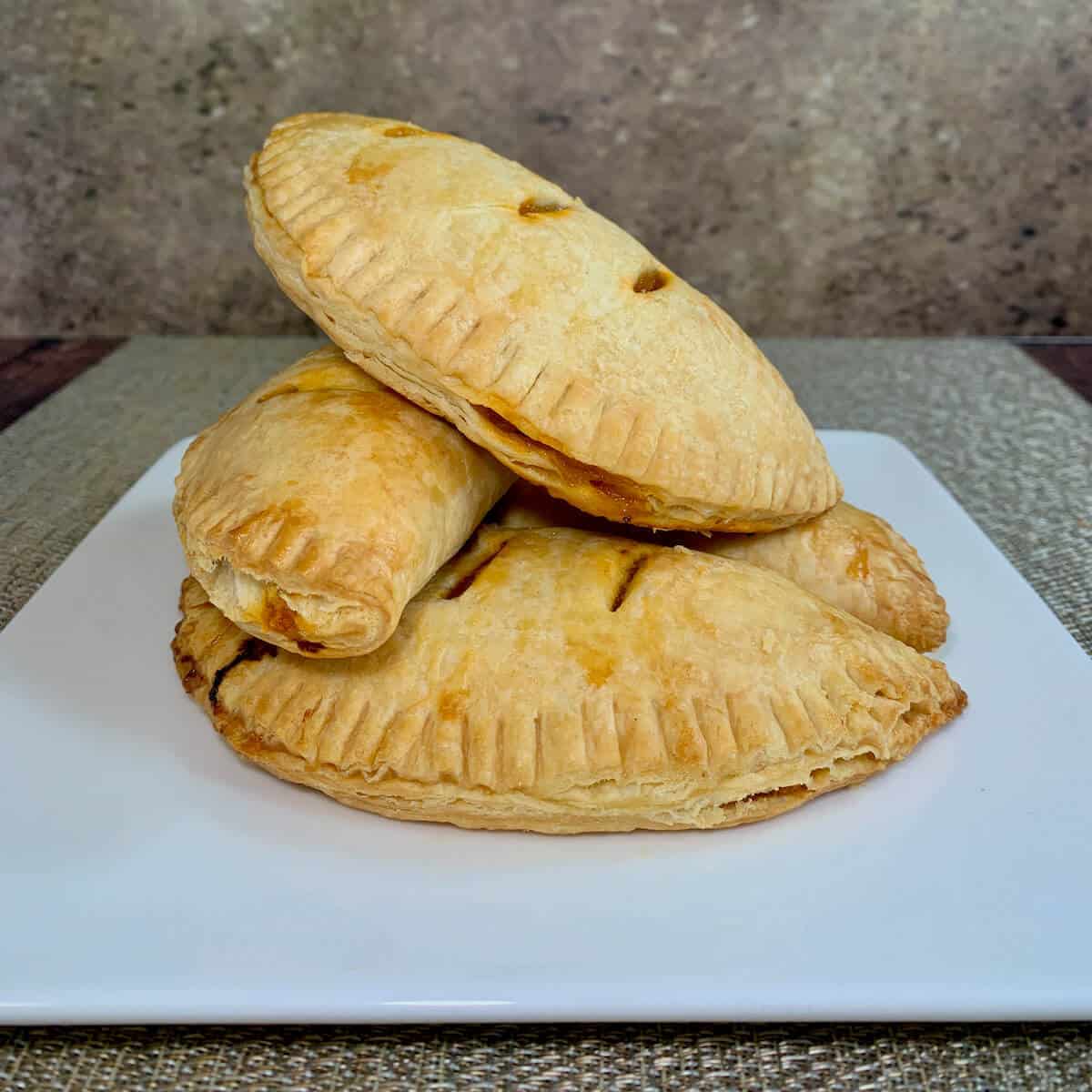 Four stacked Sloppy Joes Pasties on a white plate.