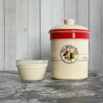Sourdough starter crock with bowl of discard.