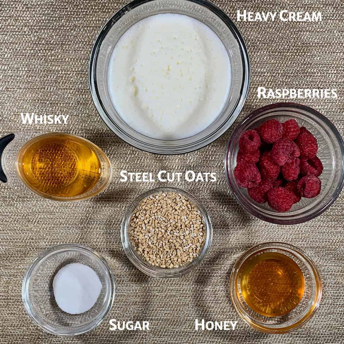 Cranachan ingredients in glass bowls from overhead.