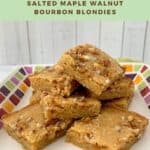 Stack of Maple Walnut Bourbon Blondies on a white plate with multicolored checks Pinterest banner.