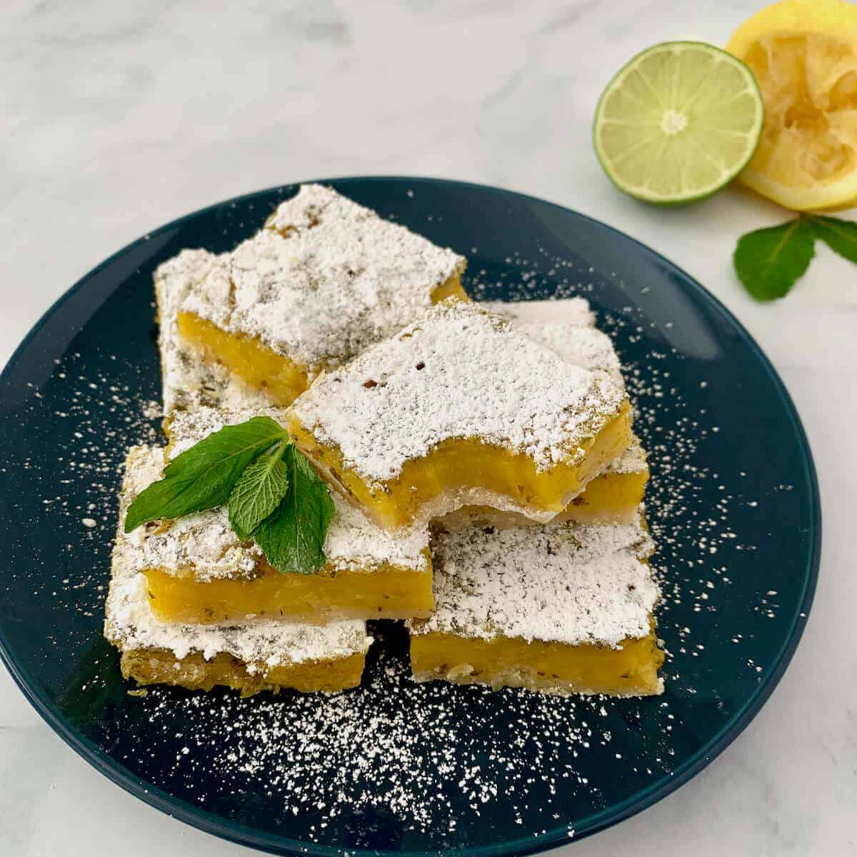 Mint Lemon Lime Bars stacked on blue plate.