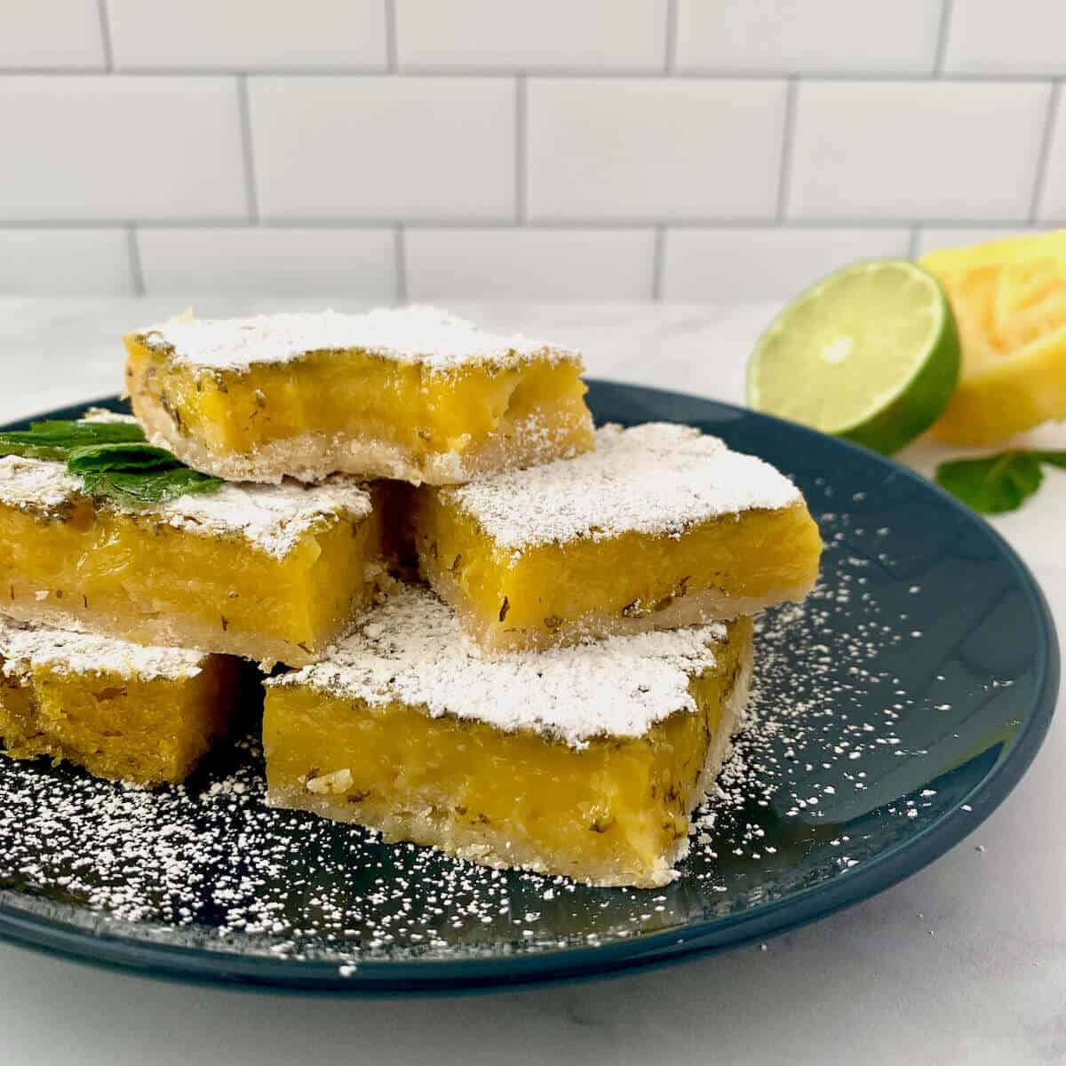 Mint Lemon Lime Bars stacked on blue plate.