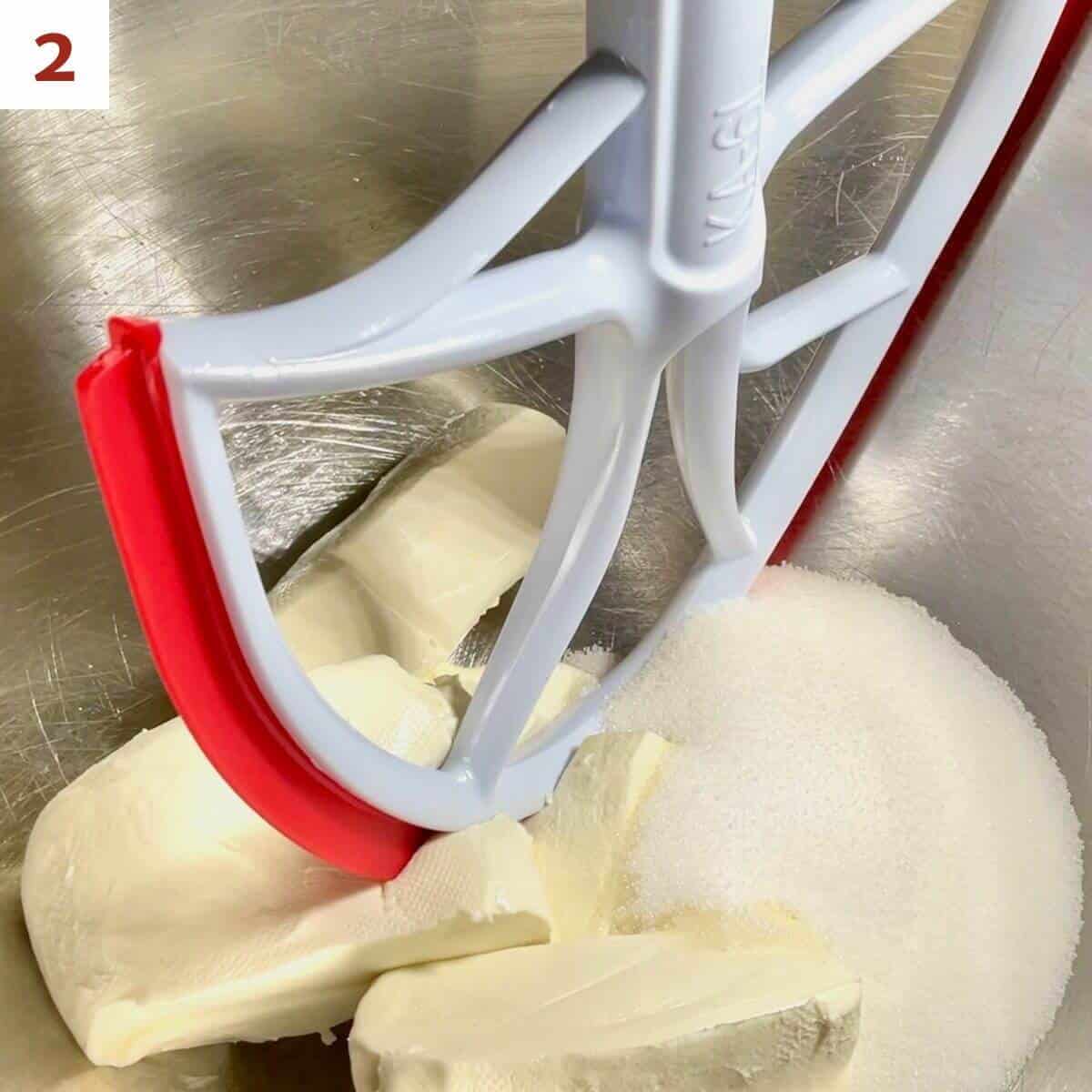 Mixing cream cheese & sugar for cheesecake base in the mixer bowl.