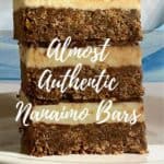 Nanaimo bars stacked on a white plate in front of a blue draped scarf Pinterest banner.