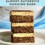 Nanaimo bars stacked on a white plate in front of a blue draped scarf Pinterest banner.