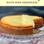 white wine cheesecake on cake plate with slice being lifted out Pinterest banner.