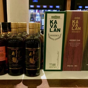 Kavalan & Nikka whisky tasting lineup in boxes & bottles on a counter.