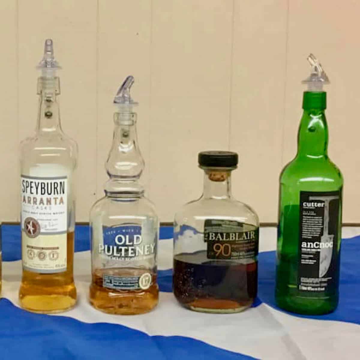 375 Park Ave Spirits Single Malt Scotch Tasting partial lineup in bottles on a Scottish flag.